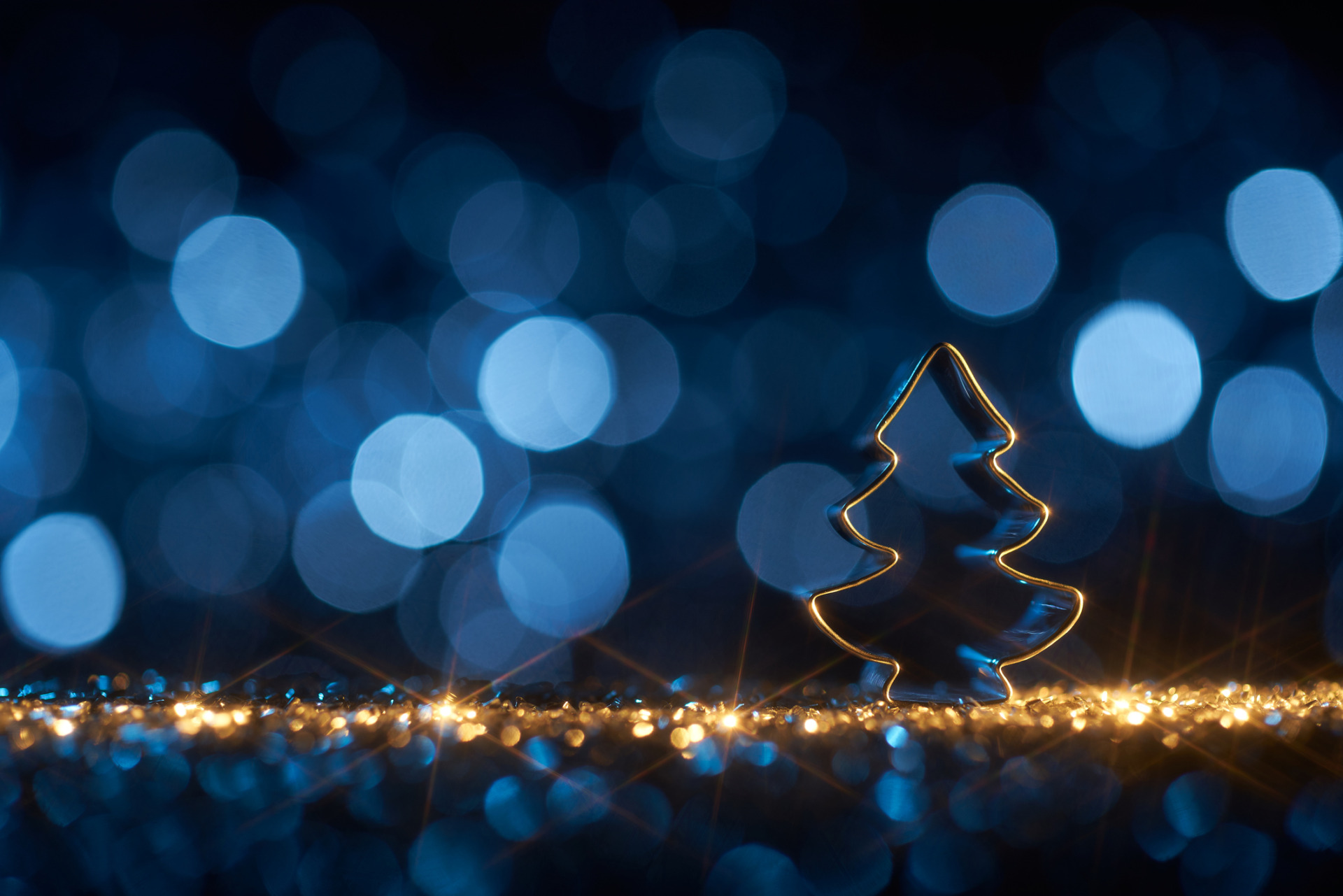 christmas tree on blue background star defocused gold bokeh